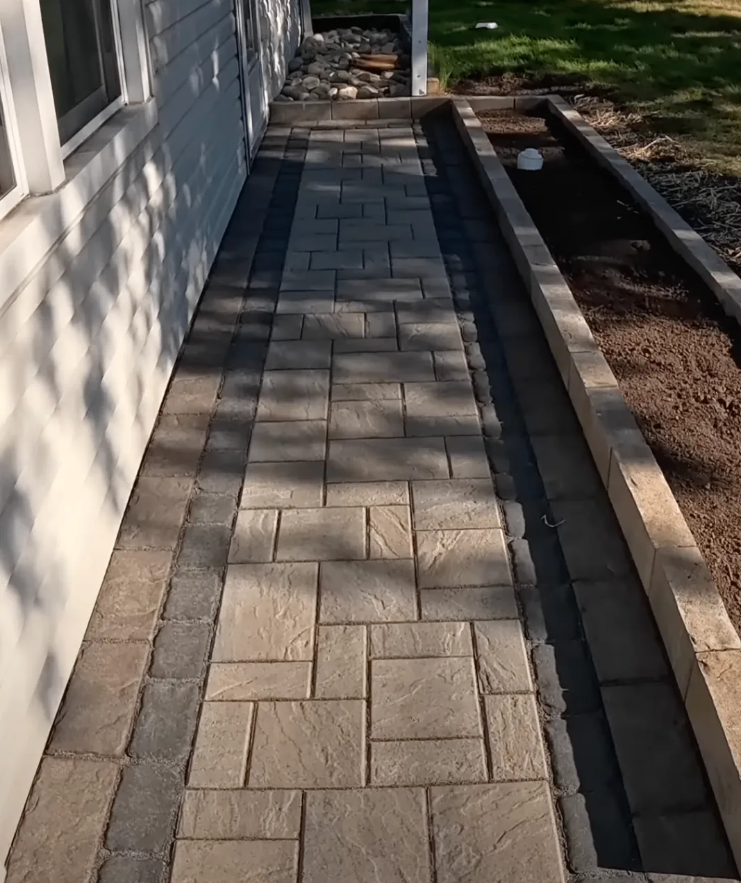 Narrow paver path with a raised garden edge