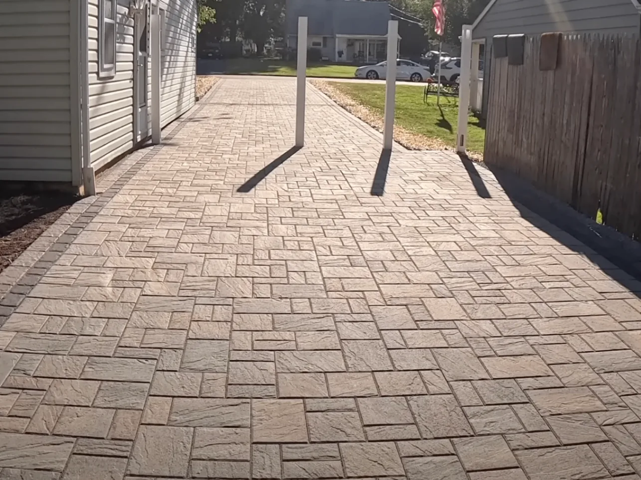 Backyard paver patio beside a fence