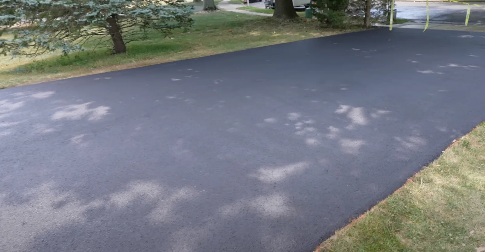 Finished driveway bordered by lawn