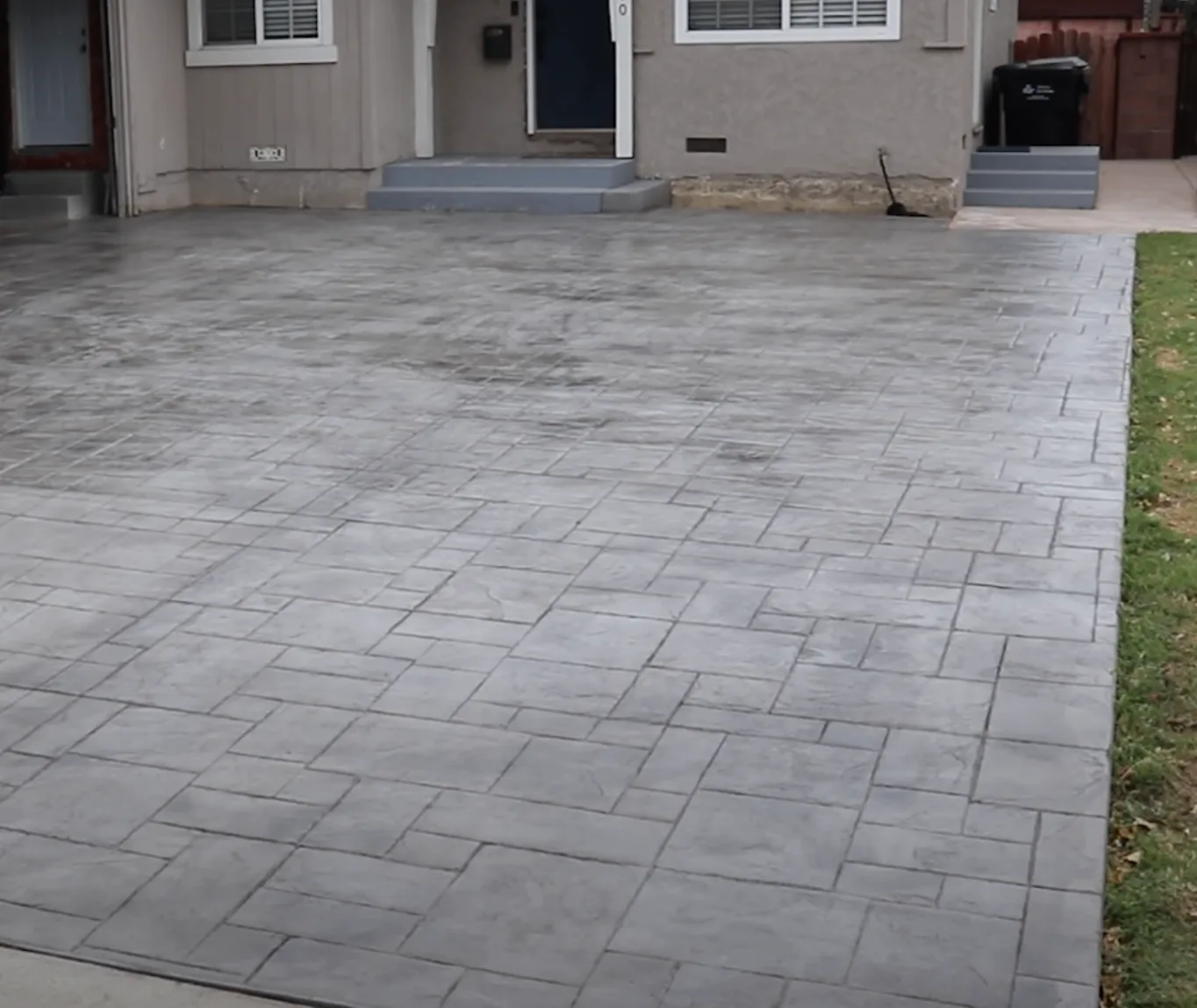 Gray paver driveway beside a home